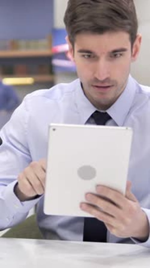 Frustrated Man Using Tablet Device in Office