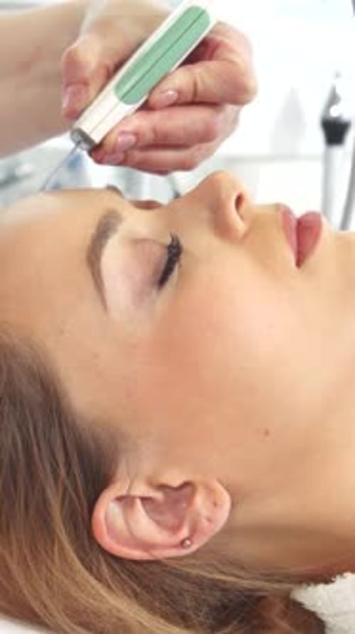 Young Woman Receives Facial Treatment at Spa