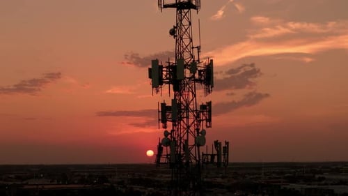 Television or Radio Telephone Tower in a Cityscape at Sunset Time Aerial Zoom Shot