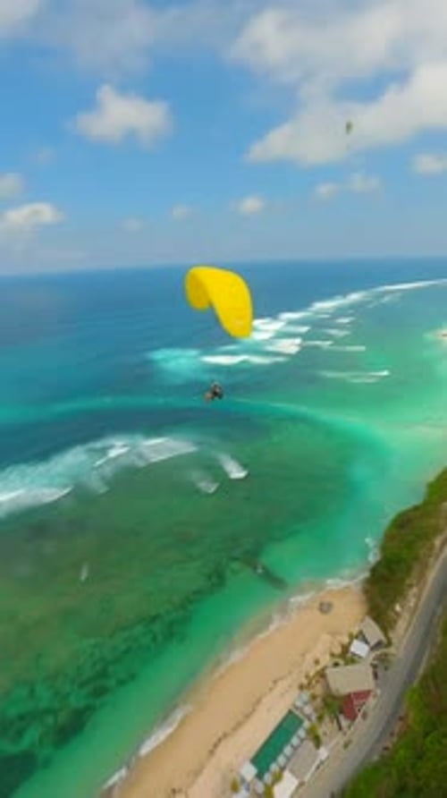 FPV Drone Shot of Paragliders Gliding Over Ocean and Cliffs in Bali Indonesia