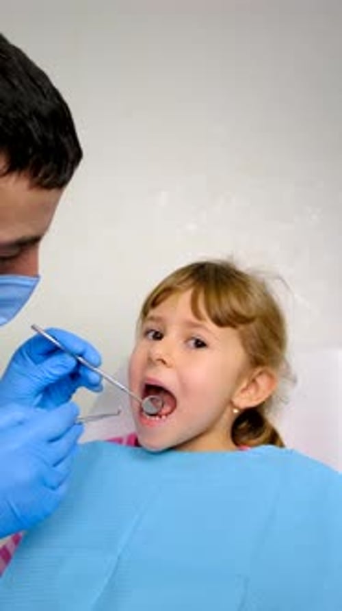 Little Girl Having Dental Exam by a Dentist