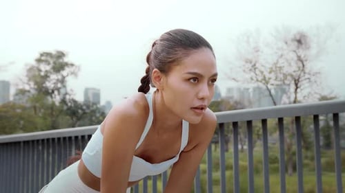 Young fitness woman in sportswear jogging in city park