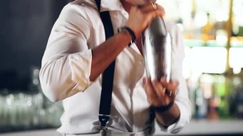 Professional Male Bartender Vigorously Shaking a Cocktail Shaker