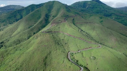 Aerial Drone Footage of Winding Mountain Road Through Green Hills