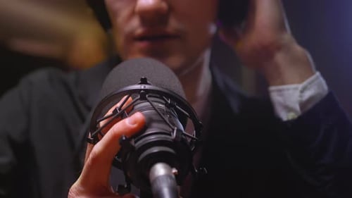 Ein Mann, ein Journalist oder Blogger, spricht ins Mikrofon, startet einen Podcast und erstellt einen Audiostream