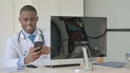 African Doctor Using Smartphone at Work in Clinic