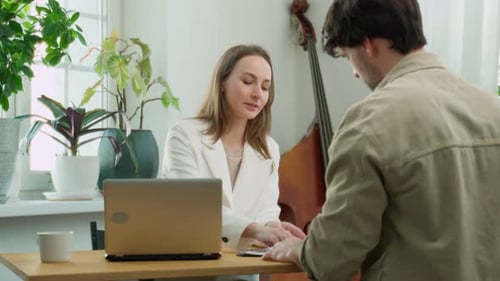 A Smiling Female Real Estate Agent Hands the Keys to a Man Buying a House a Client Becomes the Owner