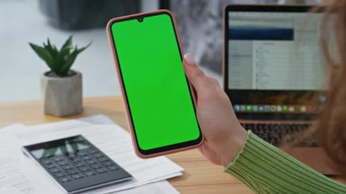 Closeup Hand Holding Mockup Cellphone in Office Woman Watching Green Screen