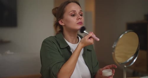 Woman Applies Makeup with Brush at Home
