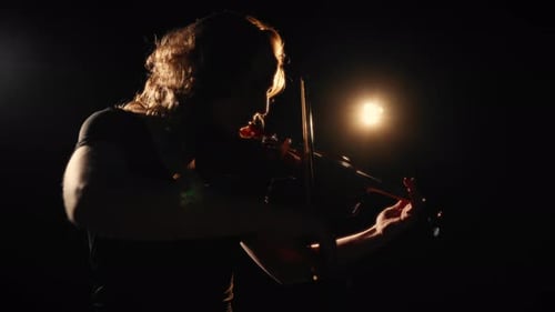 Woman Plays Violin in Dark, Dramatic Spotlight