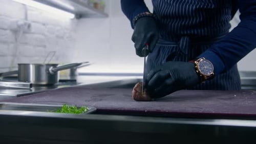 Chef Slicing Piece of Cooked Meat in Kitchen
