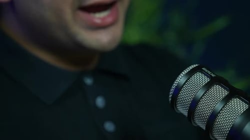 Mann spricht während eines Podcasts oder Interviews im Studio ins Mikrofon