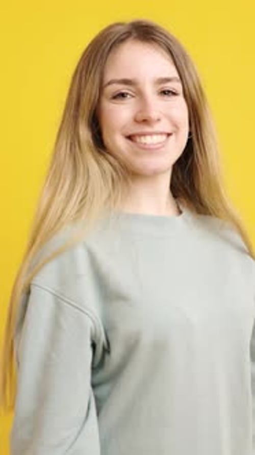 Smiling Woman Poses in Front of Yellow Background