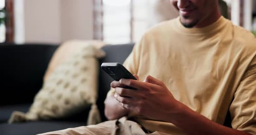 Man Relaxing on Couch Texting on Mobile Phone