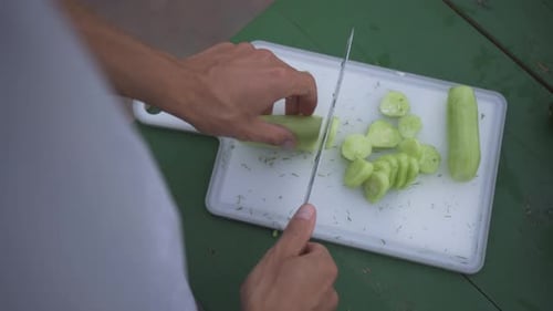 A Professional Chef Demonstrates Their Culinary Skills By Precisely Cutting a Fresh Cucumber on a
