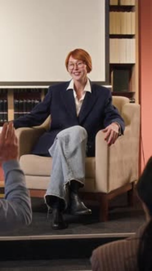 Woman Presenting to Audience in a Library Setting