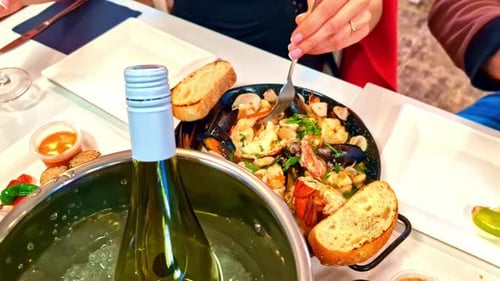 Delicious seafood meal at restaurant with wine in ice, close up