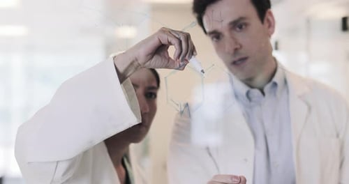 Des scientifiques dessinent une formule scientifique sur du verre