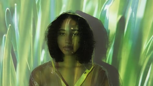 Woman in Hooded Raincoat with Abstract Background