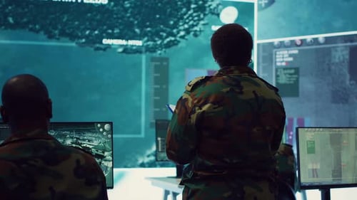 Military Personnel Analyzing Data in a Technology Office