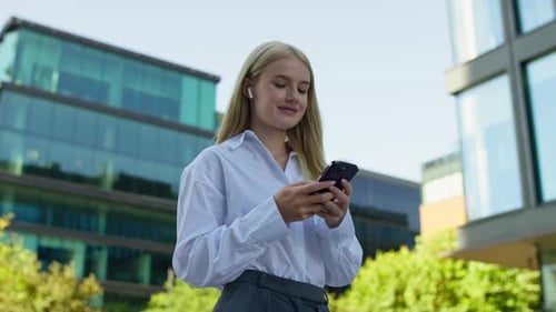 Smiling Woman Using Phone in Modern Urban Setting