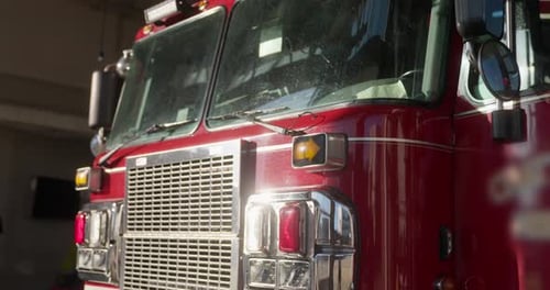 Front view of a firetruck, focusing on the windshield, grille, and headlights
