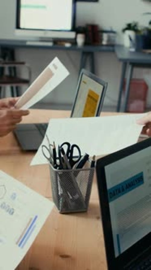 Proceso de trabajo de colegas que escriben en computadoras portátiles e intercambian documentos en la oficina