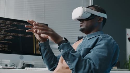 Black Male Technology Engineer Using VR Headset at Workplace