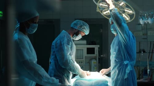 Diverse Team of Professional Male Surgeons and Female Nurse Performs Invasive Surgery on Patient in