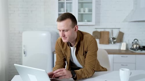 Man Using Laptop For Online Video Conference At Home