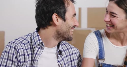 Portrait of a couple in love seated on the floor and they just bought a house and are moving. The