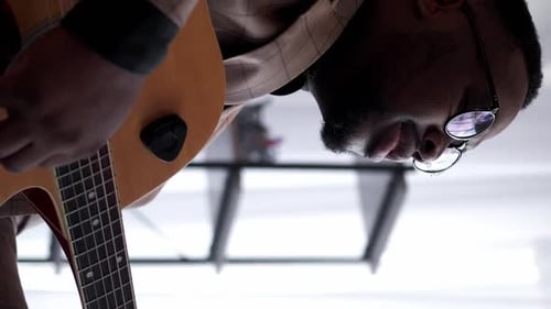 Man Plays Guitar in Close Up Indoors