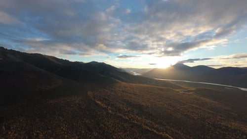 Experience breathtaking aerial views of expansive mountain landscapes illuminated by the warm hues o