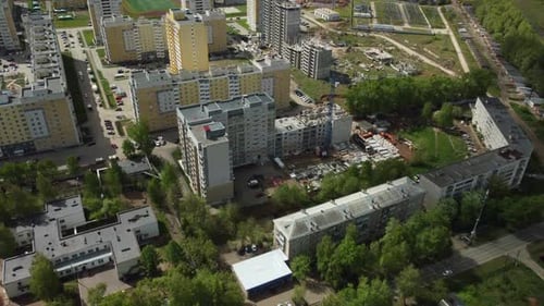 a Crane is on Top of a Building Under Construction in a City Area with Other Buildings and Cars