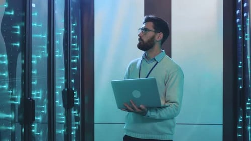 Man Holding Laptop in Futuristic Server Room
