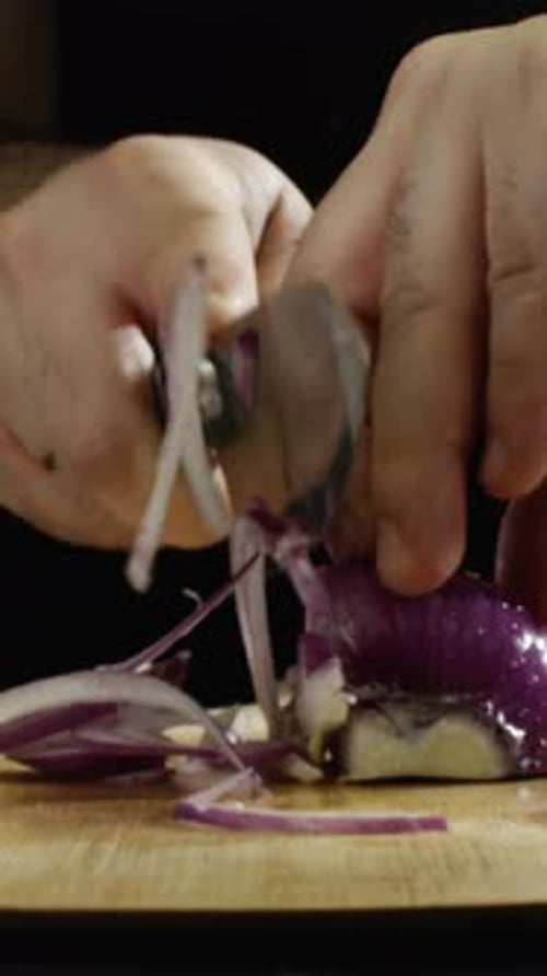 Closeup of Man's Hands Holding a Purple Onion on a Wooden Board at the Restaurant Kitchen in Slow
