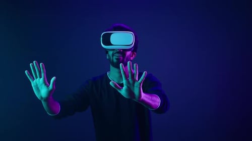 Man Experiencing Virtual Reality in Neon Lit Room
