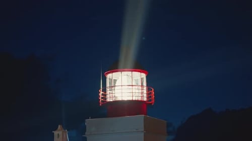 Modern Lighthouse at Dusk with Bright Light Lens Rotating and Shining Out to Ocean on Madeira Island