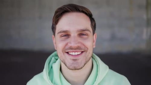 Young happy man smiling on camera outdoor, Face portrait