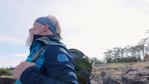 Senior Man Enjoying Scenic Coastal Hike on Sunny Day