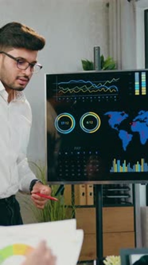 Man Presents Business Data to Colleague in Office