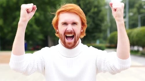 Excited Redhead Man Celebrating Success Outdoors