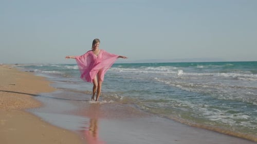 Woman Walking on Beach Shoreline in Pink Cover-up