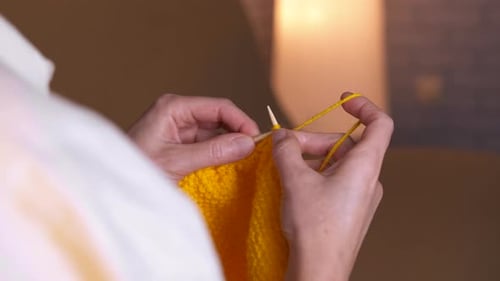 Woman's Hands Knitting Yellow Yarn Close Up