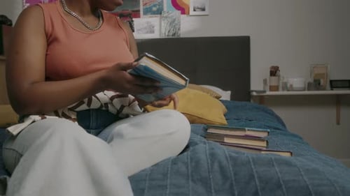 Intelligent Black Woman Reading University Textbooks in Bed