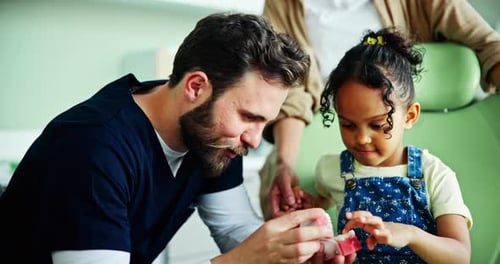 Dentist Showing Model Teeth to Young Child