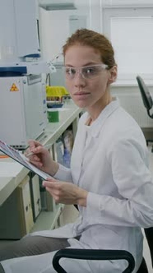 Woman Writing on Clipboard in Laboratory Setting