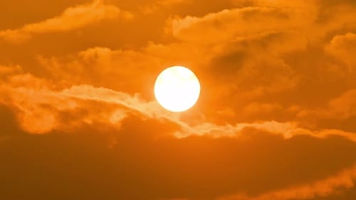 Golden Sun Shining Through Fiery Clouds at Sunset