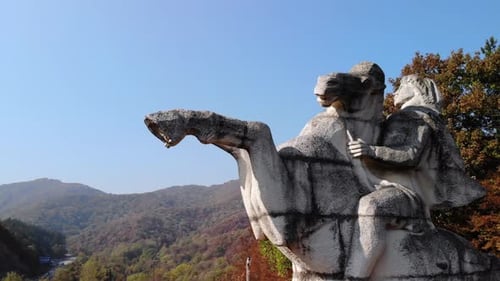 Statue de cavalier sur fond de ciel bleu avec une montagne de forêt d'automne en arrière-plan à Targovishte, Bulgarie