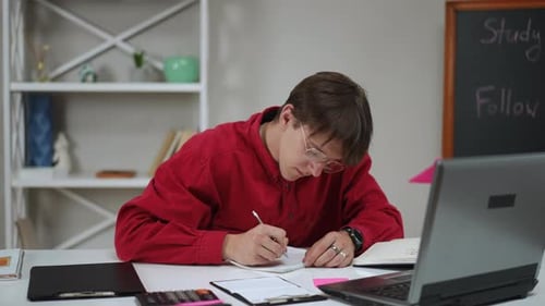Young Adult Studying at Desk with Laptop